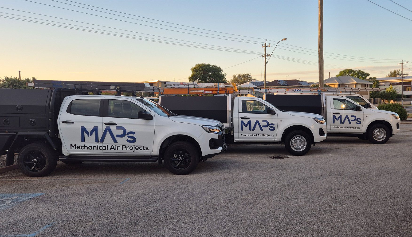 Three white service trucks with MAPS HVAC electrical services logo parked outside, ready for scheduled maintenance work
