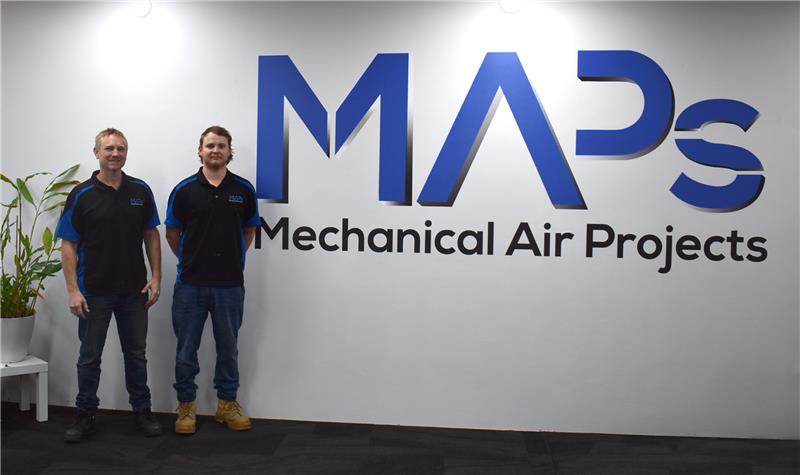 Two men stand beside a map sign labeled "MAPs Mechanical Air Projects," promoting MAPs electrical services